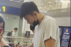 张镇麟落地上海浦东机场与球队会和 面带笑容给球迷的球衣签名